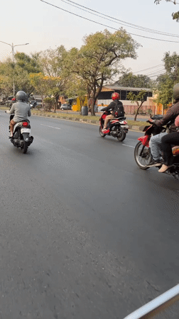 Motorcycle traffic moving through suburban Gelam streets