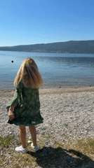 Woman dances on pebble beach in Bijela, Montenegro