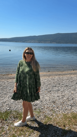 Woman dances on pebble beach in Bijela, Montenegro