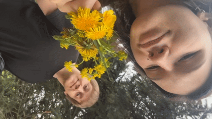 Couple poses with wildflower bouquet in Saint Petersburg park