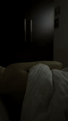 Person watches projected video while lying in Warsaw bedroom