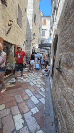Tourists explore historic Kotor, Montenegro on summer afternoon