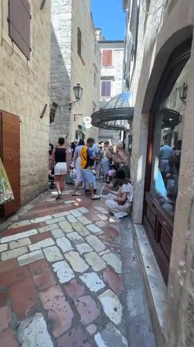 Tourists explore historic Kotor, Montenegro on summer afternoon
