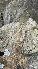 Two hikers pause on rocky mountain path in Bulgaria