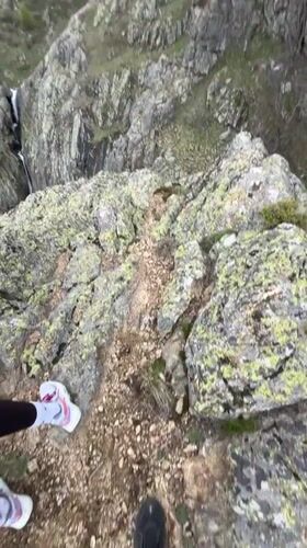 Two hikers pause on rocky mountain path in Bulgaria
