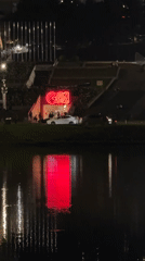 Red 'GO!' neon sign reflects in Da Lat waters