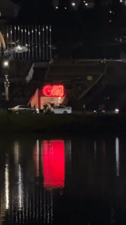 Red 'GO!' neon sign reflects in Da Lat waters