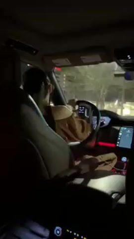 A woman in an off-the-shoulder top drives a luxury car at night. The interior is illuminated with red accent lighting. The video is shot from the back seat, and the driver's face is visible in profile. Buildings and streetlights are visible through the windshield. The car is stopped at a traffic light. The woman says, "You're too big for me." Then asks, "So, you went there?"