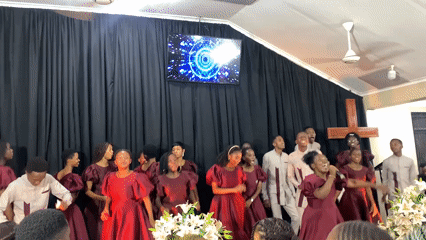 Choir performs in matching maroon uniforms on Dar es Salaam stage