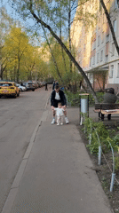 Adult helps toddler walk on Moscow sidewalk