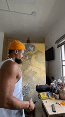 Artist works on figure painting in Ado studio