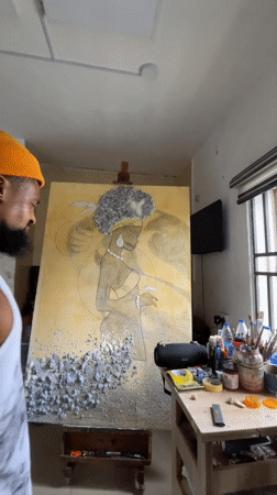 Artist works on figure painting in Ado studio