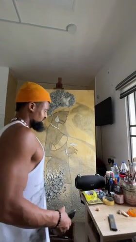 Artist works on figure painting in Ado studio
