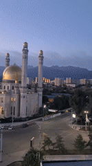 Illuminated mosque anchors Almaty skyline at dusk
