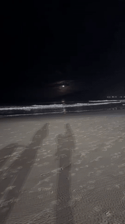 Moonlit beach vigil captured at Florianópolis shrine