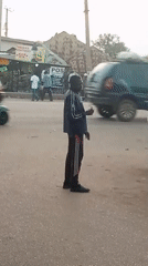 Man in striped jacket observed on rural street corner