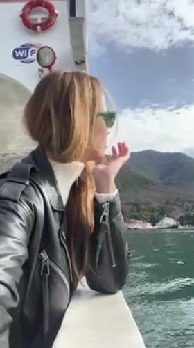 Woman documents scenic Montenegro ferry crossing on Bay of Kotor
