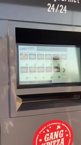 A close-up shot shows a digital menu for "Gang of Pizza" displayed on a touchscreen kiosk. The screen displays various pizza options with images, names, descriptions, and prices. Pizzas like "Frite cheddar bacon," "Mozza," "Boursin," "Raclette," "Chèvre Miel," "Reine," "Burger," "Savoyarde," "Indiana," "Cannibale," and "Margarita" are visible. Each pizza has options for "Cold" and "Hot" with corresponding prices. There are also navigation buttons at the bottom for "Homepage," "Language," "Accessibility mode," and "Online sale." A green arrow indicates there are more products to view. A red circular sticker with "PIZZAS GOURMETS" is visible at the bottom of the kiosk.