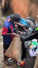 Scavenging through an overflowing bin in Ihiagwa, Nigeria