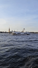 White hydrofoil crosses Neva River at sunset in Saint Petersburg