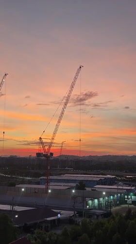 Sunset illuminates construction cranes across Pattaya City skyline