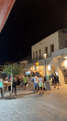 Lively summer night on a lit cobblestone street in Chania