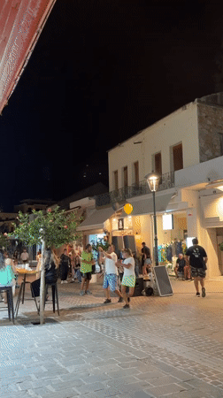 Lively summer night on a lit cobblestone street in Chania