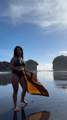Woman displays patterned scarf on Indonesian beach