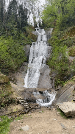 Waterfall flows over rocky tiers in Georgian forest
