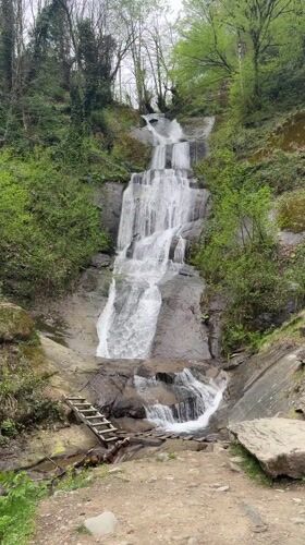 Waterfall flows over rocky tiers in Georgian forest