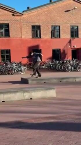 Skateboarders practice tricks in Copenhagen plaza on sunny afternoon