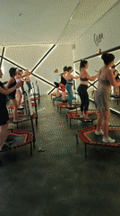 Mini-trampoline fitness class in a neon-lit studio