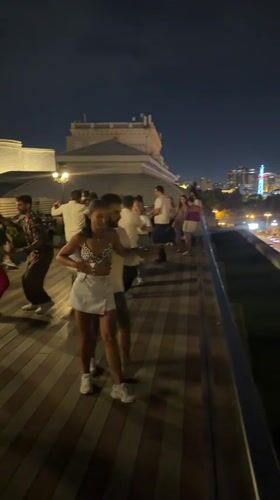 Rooftop dancing in Baku with the city skyline at night