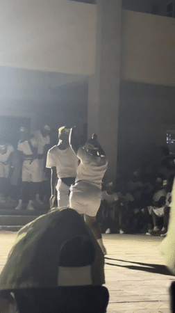 Two people in white attend nighttime outdoor event in Maiduguri
