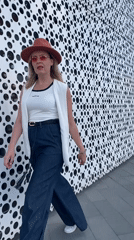 Woman poses with perforated building facade in Yekaterinburg