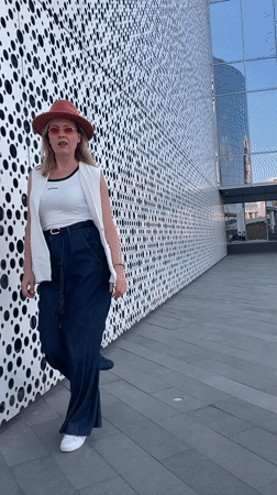 Woman poses with perforated building facade in Yekaterinburg