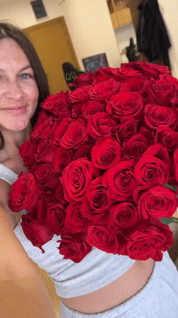Woman celebrates with roses and balloons in Montenegro home