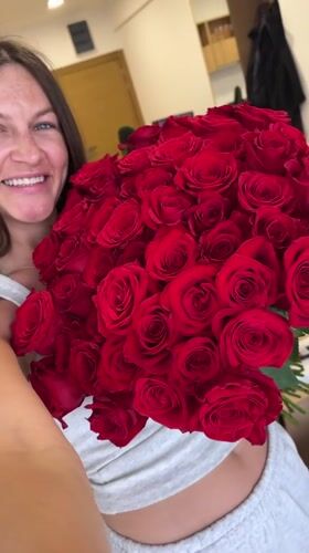 Woman celebrates with roses and balloons in Montenegro home