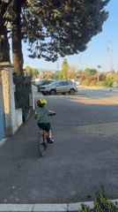 Child rides red bicycle in Rousset, France
