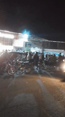 Nighttime crowd gathers at lit building in Narayi, Nigeria