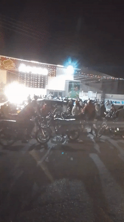 Nighttime crowd gathers at lit building in Narayi, Nigeria