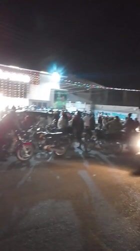 Nighttime crowd gathers at lit building in Narayi, Nigeria