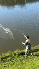 Nighttime fisherman casts net into lake in Da Lat