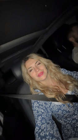 Woman films singing selfie video from car passenger seat Montenegro