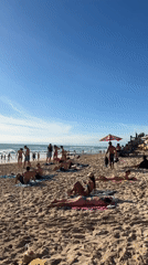 Busy morning beach scene captured at Kuta Selatan