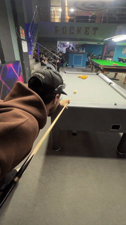 Man plays billiards at Meknes pool hall