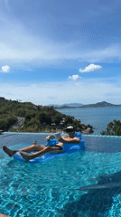 Tourist relaxes on inflatable raft in Ko Samui infinity pool