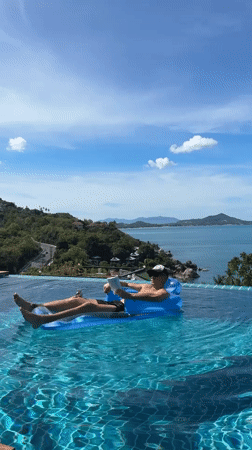 Tourist relaxes on inflatable raft in Ko Samui infinity pool