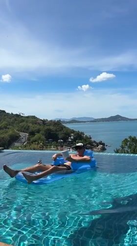 Tourist relaxes on inflatable raft in Ko Samui infinity pool
