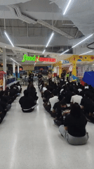Crowd seated on mall floor facing a stage in Ko Samui